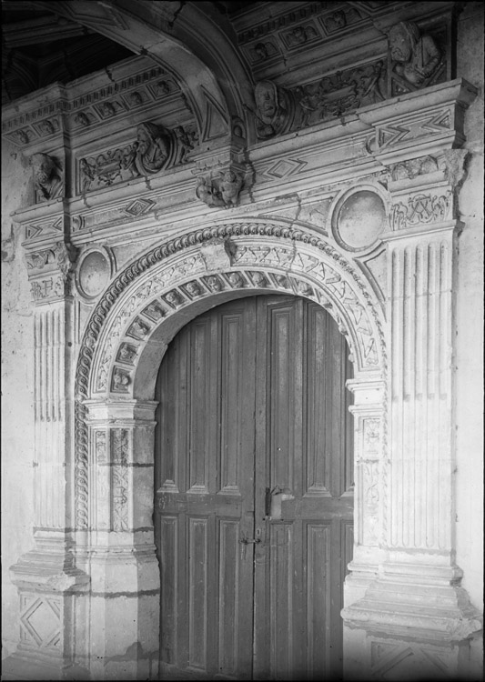 Cour intérieure, galerie du rez-de-chaussée : porte de la chapelle, surmontée de modillons