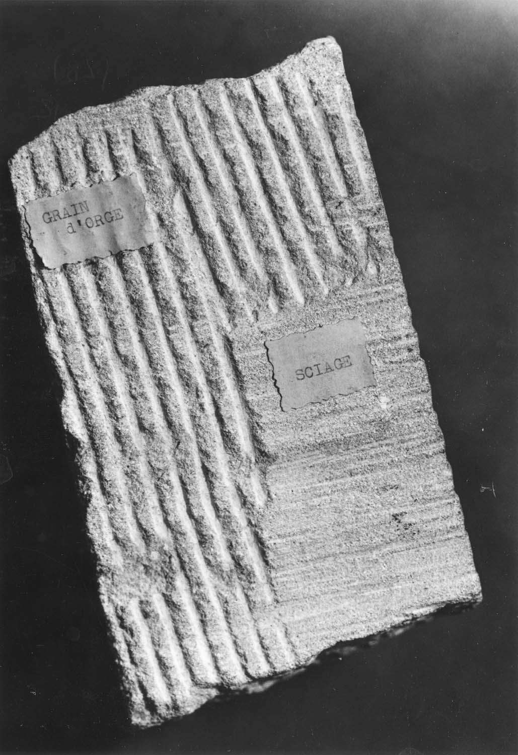 Différentes traces modernes de tailles de pierre et sciage, sur chaque face du bloc de pierre : taillant droit, chemin de fer, bretture, grain d’orge