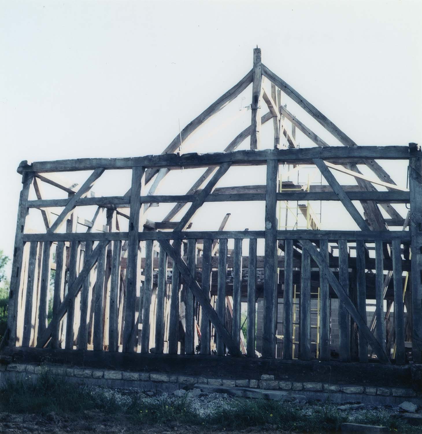 Maison en colombage en cours de remontage après déplacement ; construction à pans de bois