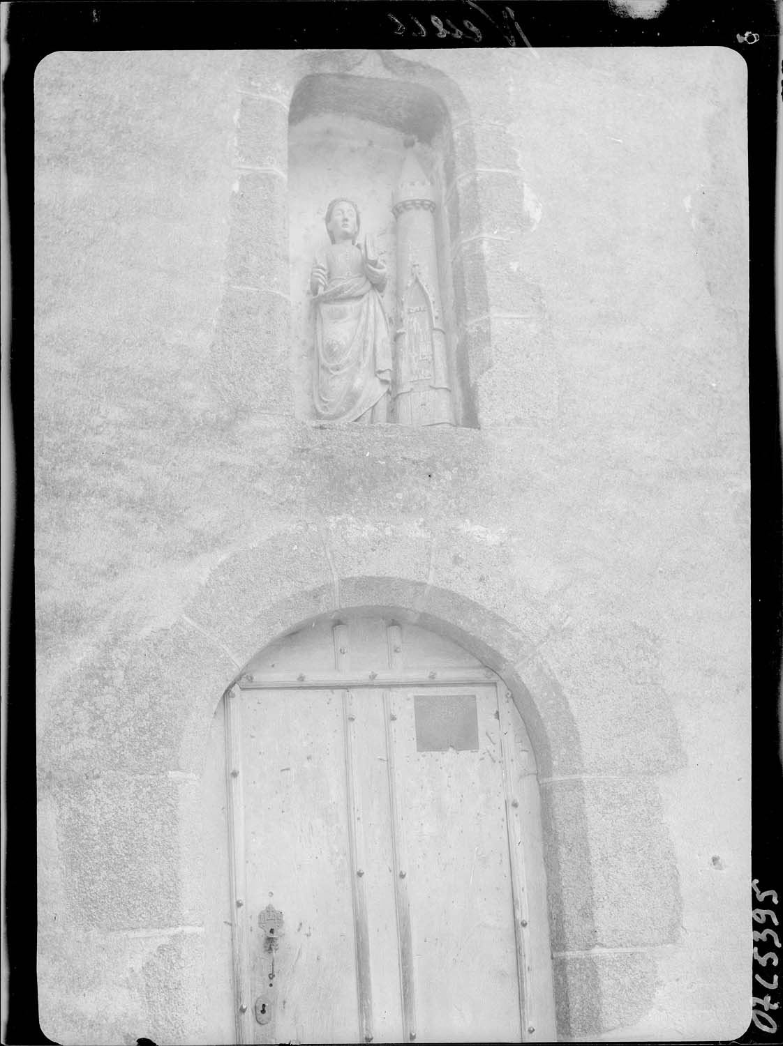 Statue de sainte Barbe située dans une niche au-dessus de la porte de la façade nord de l'église