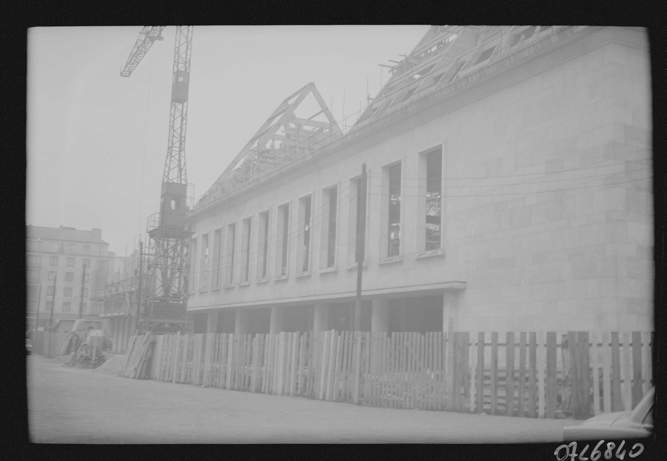 Façade neuve achevée et charpente en cours de montage