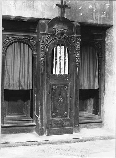 Confessionnal : bois sculpté de chutes de fleurs, cartouche, rosaces, volutes