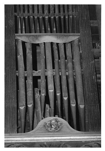 Buffet d'orgue : détail des tuyaux et d'un chérubin en bois sculpté ; avant restauration