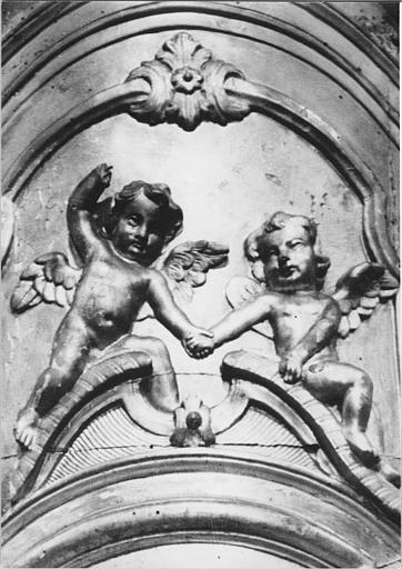 Tabernacle : détail de deux angelots sculptés en bas-relief au-dessus de la porte du tabernacle, bois sculpté, doré