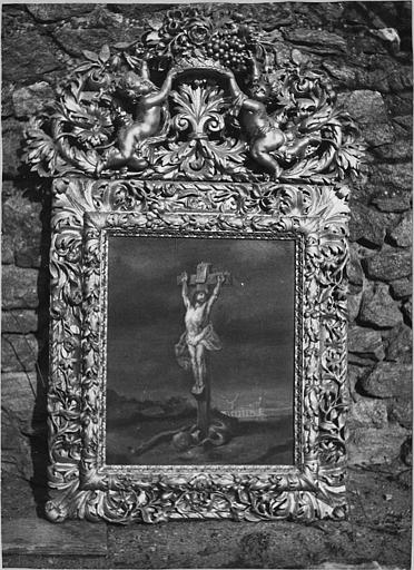 Cadre : cadre à fronton, bois sculpté de motifs végétaux et putti portant une corbeille de fleurs