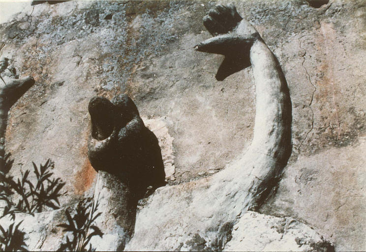 Bas-relief : détail d'un personnage à tête de canard, bec ouvert, bras levés