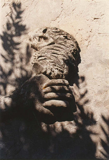 Bas-relief : détail d'une tête d'oiseau tenue par une main