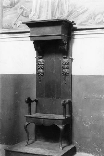 Trône abbatial formé par deux éléments provenant de meubles différents, le dais comporte des consoles sculptées de chérubins et deux chutes de fleurs, bois taillé, sculpté