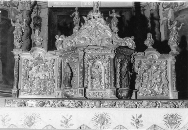 Tabernacle architecturé surmonté d'une exposition, agrémenté de plusieurs statuettes d'anges et de saints personnages, et de 2 bas-reliefs représentant l'Adoration des bergers et l'Adoration des mages, bois sculpté, doré