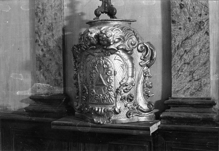Tabernacle en forme d'urne sculptée de volutes, fleurettes, coquille et éléments rocailles, avec la porte ornée d'une Gloire et surmontée de deux chérubins, bois sculpté, doré