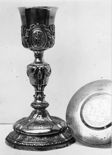 Calice à médaillon représentant le Christ en croix, décor d'épis de blé et grappes de raisin, drapés, frises de motifs végétaux, patène gravée de palmes, de rosaces, de la couronne d'épines et du monogramme IHS, argent doré - © Ministère de la Culture (France), Médiathèque du patrimoine et de la photographie (objets mobiliers), tous droits réservés