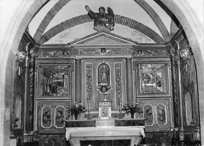 Retable architecturé à 3 travées, orné de plusieurs bas-reliefs représentant des scènes de l'ancienne abbaye de Lézat, des profils de moines, la niche central abrite une statue de saint Antoine, le fronton est surmonté de Dieu le Père, bois sculpté, peint, doré - © Ministère de la Culture (France), Médiathèque du patrimoine et de la photographie (objets mobiliers), tous droits réservés