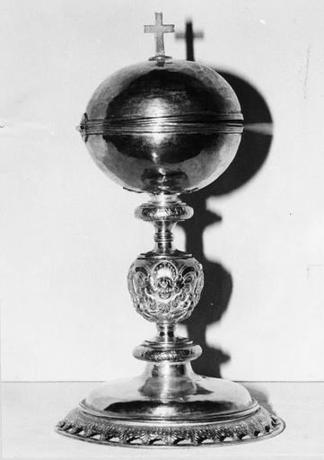 Ciboire au couvercle à charnière, noeud travaillé au repoussé de chérubins et fruits, pied à frise de feuilles ajourée, argent