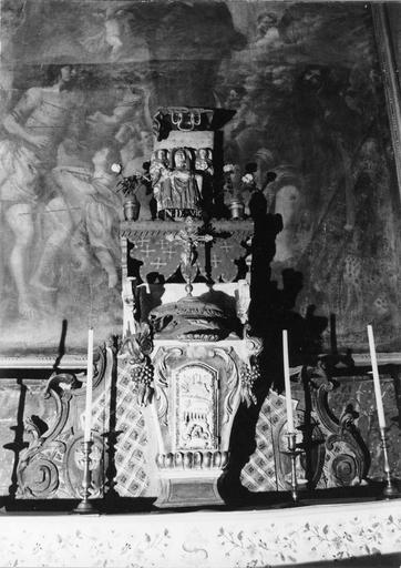 Tabernacle en forme d'urne ornée de l'Agneau immolé, de grappes de raisins, placé devant un panneau à deux médaillons représentant des ciboires en relief, surmonté du groupe sculpté d'une Vierge de Pitié dite Notre Dame de Vic, bois sculpté, peint, doré