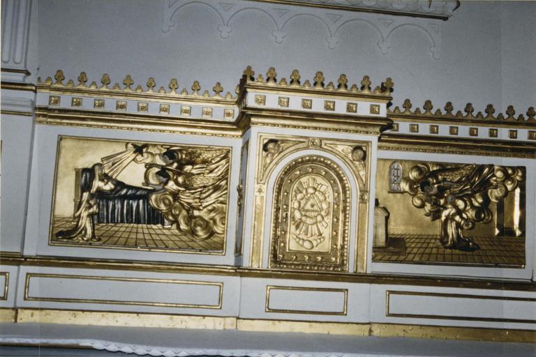 Tabernacle quadrangulaire à ailes en bois doré et polychrome, reposant sur une prédelle polychrome et sommé d'une corniche tréflée, la porte du tabernacle est décorée d'un triangle rayonnant, chargé d'une couronne de nuées, le tout entouré d'étoiles à cinq branches, le tout doré surmonté dans les coins supérieurs de deux têtes d'anges polychromes, les ailes sont chargées de deux panneaux en bois doré et argenté, à gauche : La Dormition de sainte Thérèse d'Avila, et à droite : La Transverbération de saint Thérèse d'Avila, 18e-19e siècle - © Ministère de la Culture (France), Médiathèque du patrimoine et de la photographie (objets mobiliers), tous droits réservés