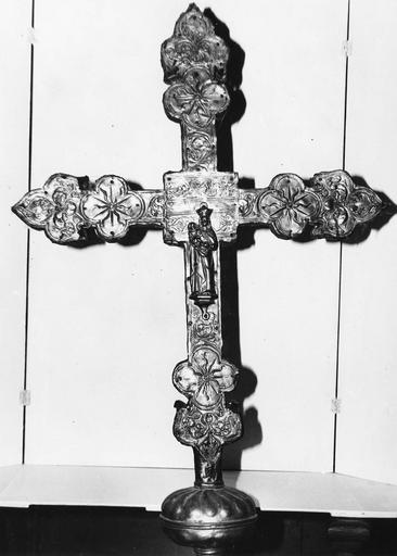 Croix de procession comportant une statuette de la Vierge à l'Enfant en son centre, aux branches terminées par des fleurs de lys et un motif quadrilobé, cuivre repoussé sur âme de bois (revers)
