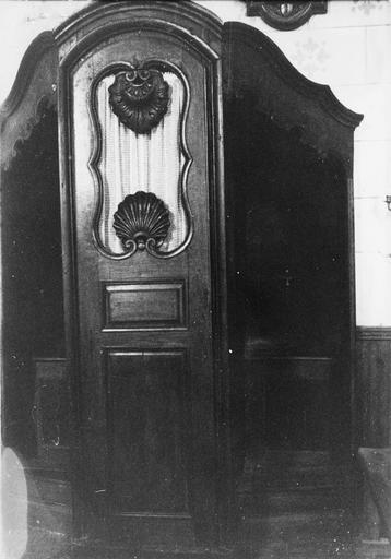 Confessionnal à corniche mouvementée et porte centrale ajourée et sculptée de deux coquilles différentes, bois taillé, sculpté