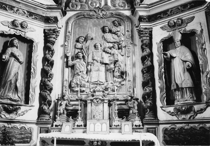 Tabernacle, retable, bas-relief, statues (2) : La lapidation de saint Etienne, Sainte Marie, Saint Blaise, retable architecturé, tabernacle architecturé encadré par deux volutes sur lesquelles sont juchés deux angelots, bois sculpté, peint, doré