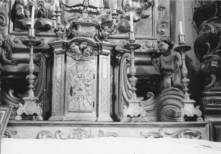 Tabernacle architecturé en forme de lanternon, flanqué de deux volutes surmontées de deux angelots adorateurs, bois sculpté, peint, doré