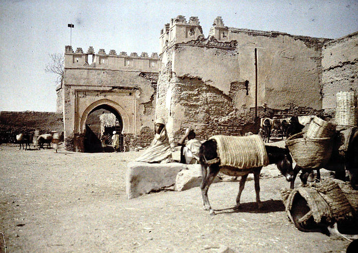 Porte de ville sur les remparts, personnages et ânes