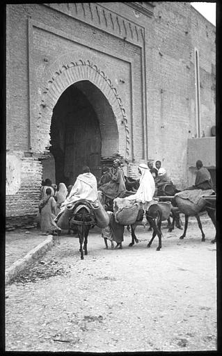 Marocains sur des ânes franchissant la porte des remparts