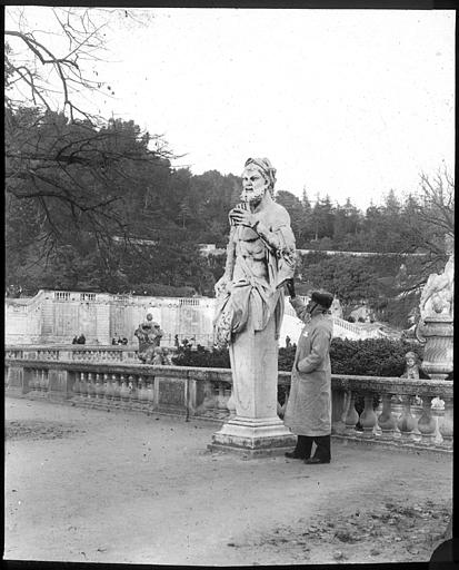 Homme posant à côté d'une grande statue