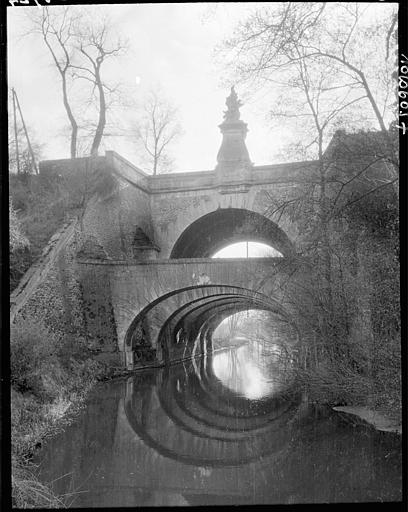 Vue d'ensemble : arches, fontaine, reflets dans l'eau