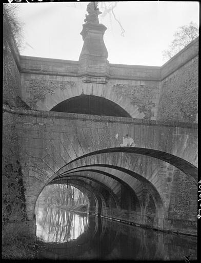 Vue d'ensemble : arches, fontaine, reflets dans l'eau