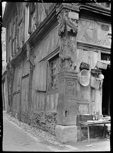 Poteau-cornier sculpté à l'angle des rues, façade décorée de paniers d'osier