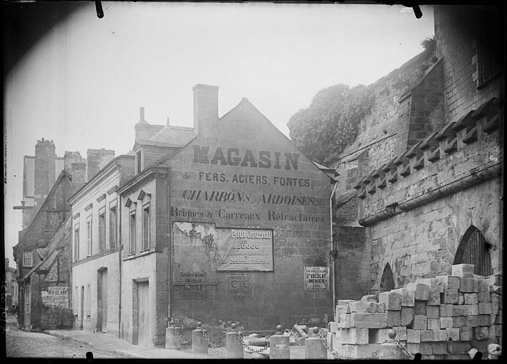 Façade sur rue, côté gauche, affiches sur le pignon d'une maison