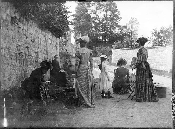 Groupe de femmes devant un mur en pierres