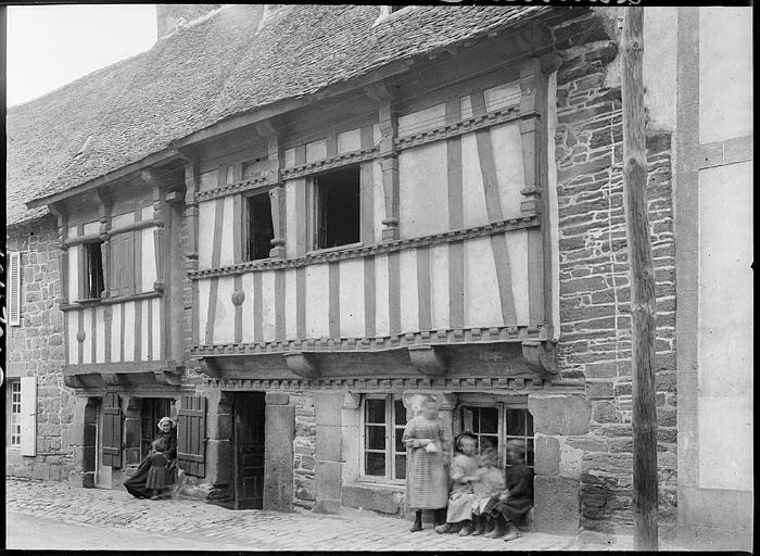 Façades sur rue, famille devant une fenêtre