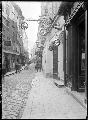 Rue ancienne pavée, enseignes en fer forgé
