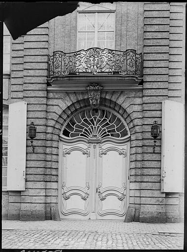 Porte d'entrée, tympan vitré et balcon en fer forgé