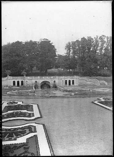 Parc : terrasse en terre-plein à balustrade, bassin et fontaine, parterres de fleurs