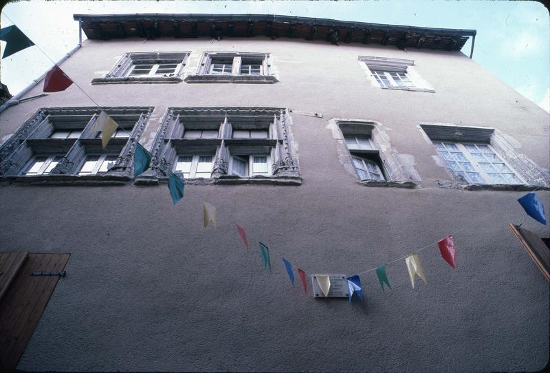 Façade d'immeuble crépie avec des restes de fenêtres de style Renaissance. Plaque indiquant qu'il s'agit de la maison natale de Dominici