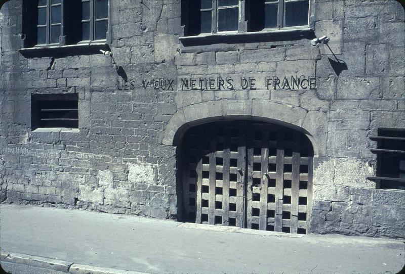 Façade sur rue : porte de la cave, surmontée de l'enseigne : les vieux métiers de France