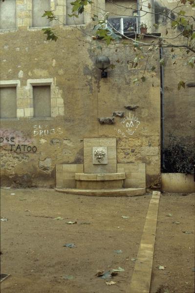 Fontaine et graffitis sur la façade
