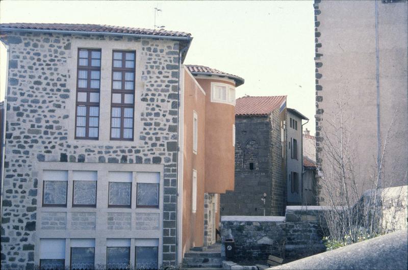 Maison restaurée avec tourelle et maison romane en arrière-plan