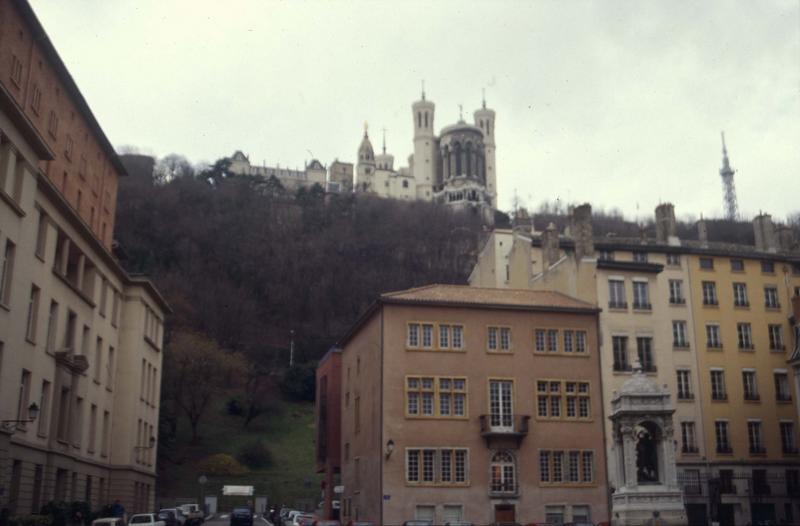 Place Saint-Jean : façades d'immeubles, fontaine et vue sur la basilique de Fourvière