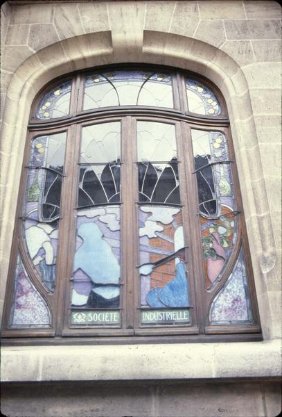 Fenêtre du rez-de-chaussée sur rue avec vitrail