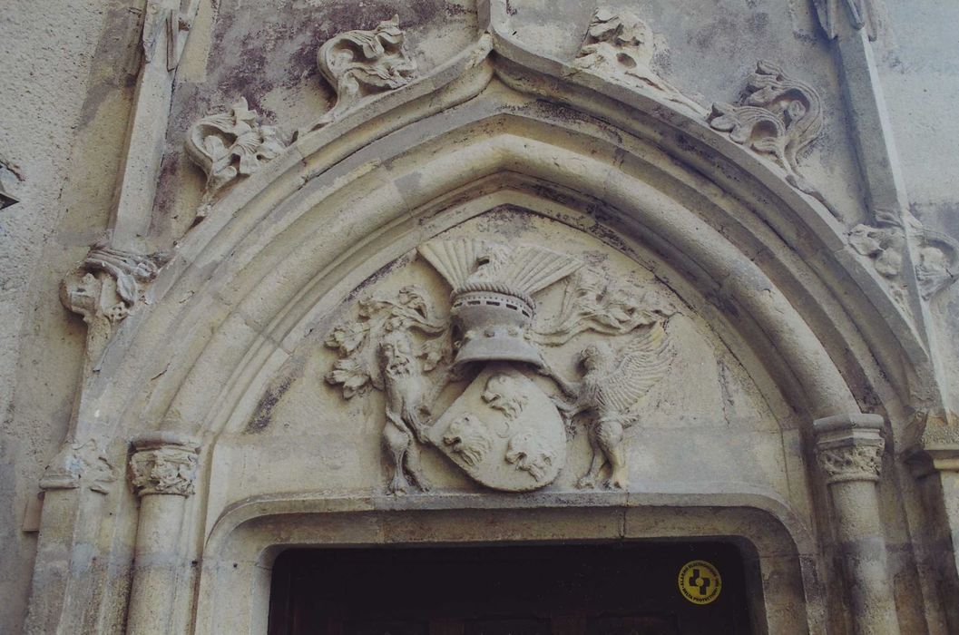 Château de la Poivrière : Cour intérieure, façade ouest, détail du tympan de la porte d’accès à la tour d’escalier