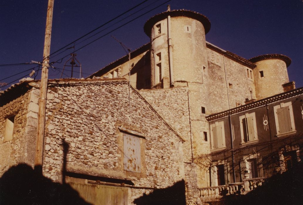 Château de Rustrel : Vue partielle du château dans son environnement urbain depuis le Sud-Est