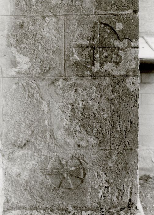 façade latérale sud, détail de réemploi de pierres sculptées dans le contrefort de droite du porche couvert