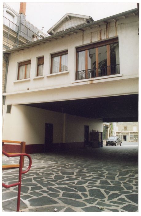 maison particulière édifiée au-dessus de l’allée menant au cinéma, façade sur cour
