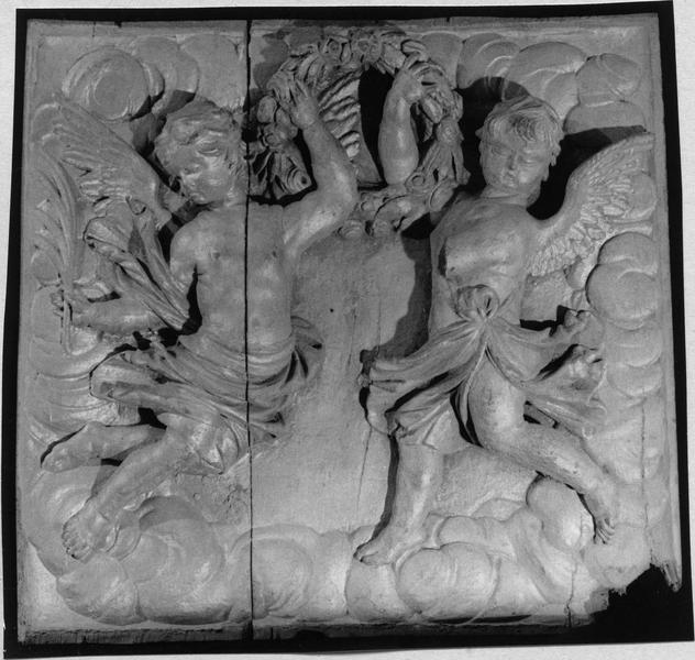 relief sculpté : deux angelots sur une nuant tenant une couronne de fleurs