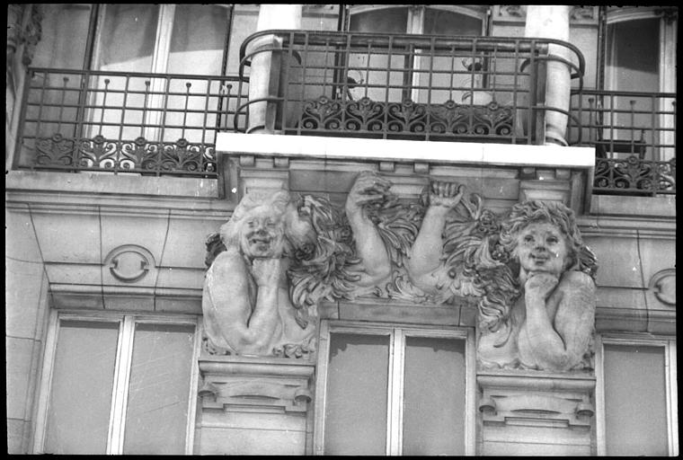 Façade ornée de deux cariatides en buste : vue rapprochée
