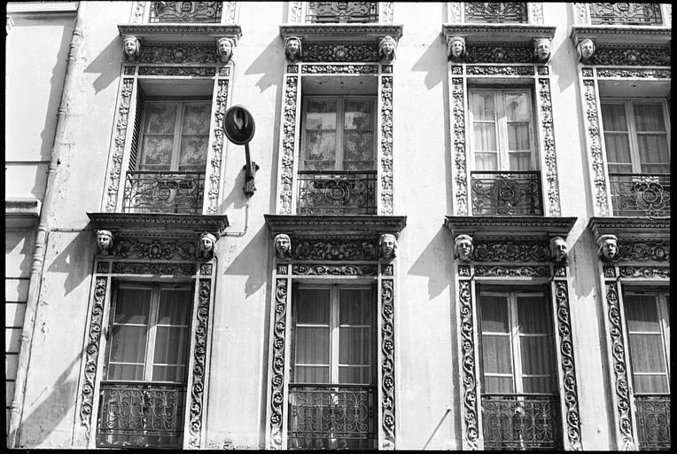 Façade ornée de têtes masculines et féminines supportant des corniches