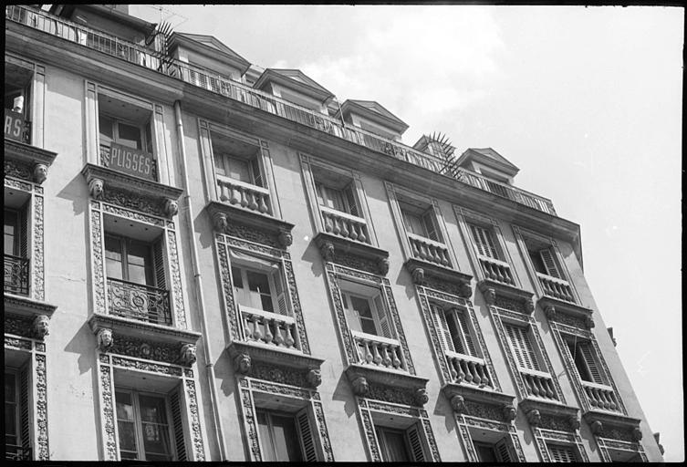 Façade ornée de têtes masculines et féminines supportant des corniches