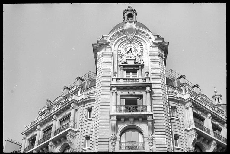 Angle de deux façades : horloge soutenue par deux atlantes en pied